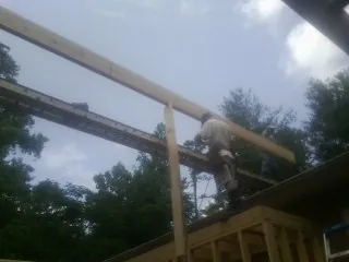 Carpenter setting a ridge beam over a new addition frame — Ice Dam Removal by Roofing Brothers in Glastonbury