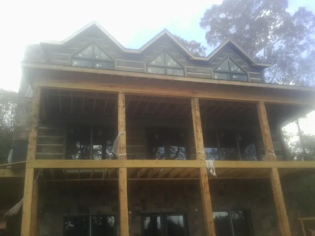 Dormers and porch framing on a large log home under construction — Roof Coating work by our crew in Glastonbury