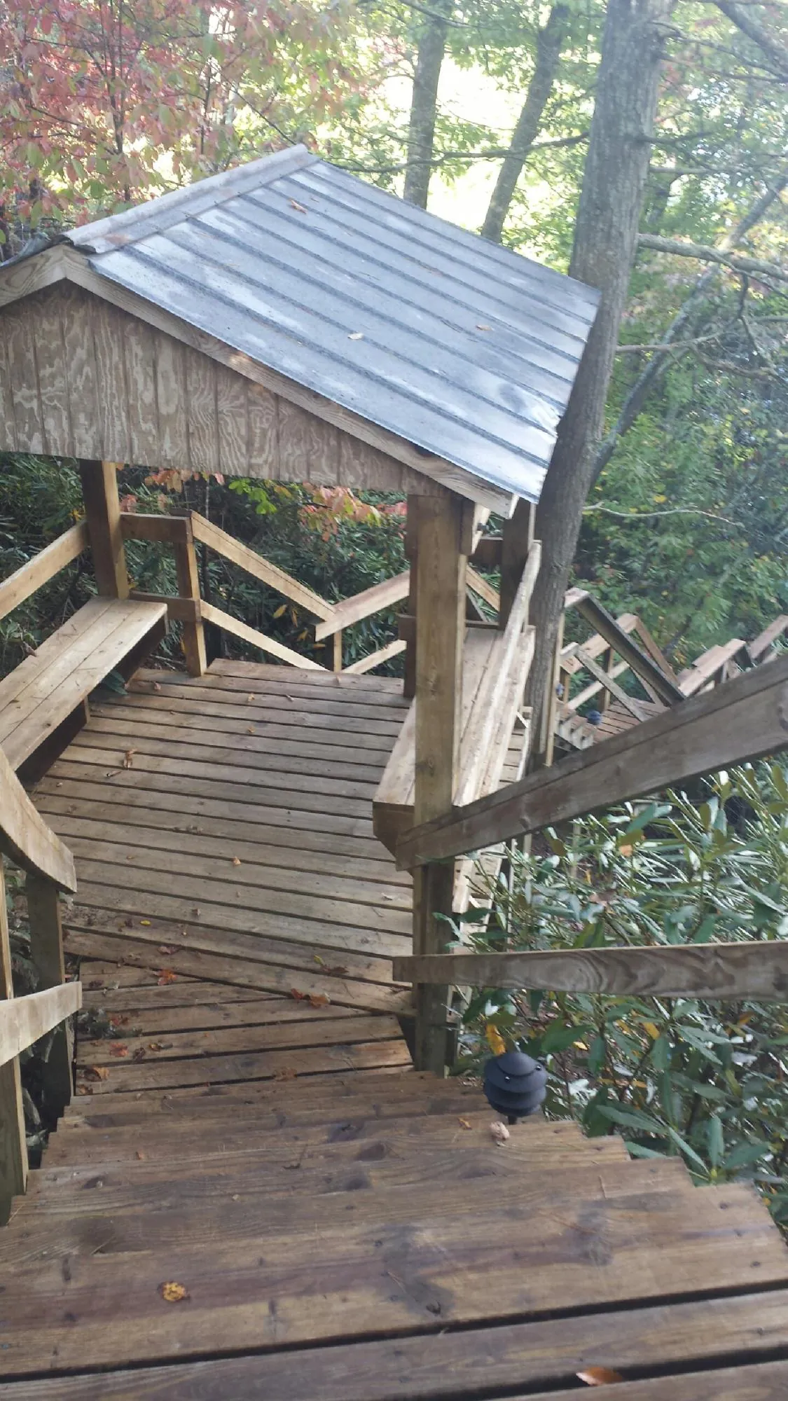 Metal roofed shelter over wooden steps on a wooded walkway — Skylight Repair & Installation work by our crew in Glastonbury
